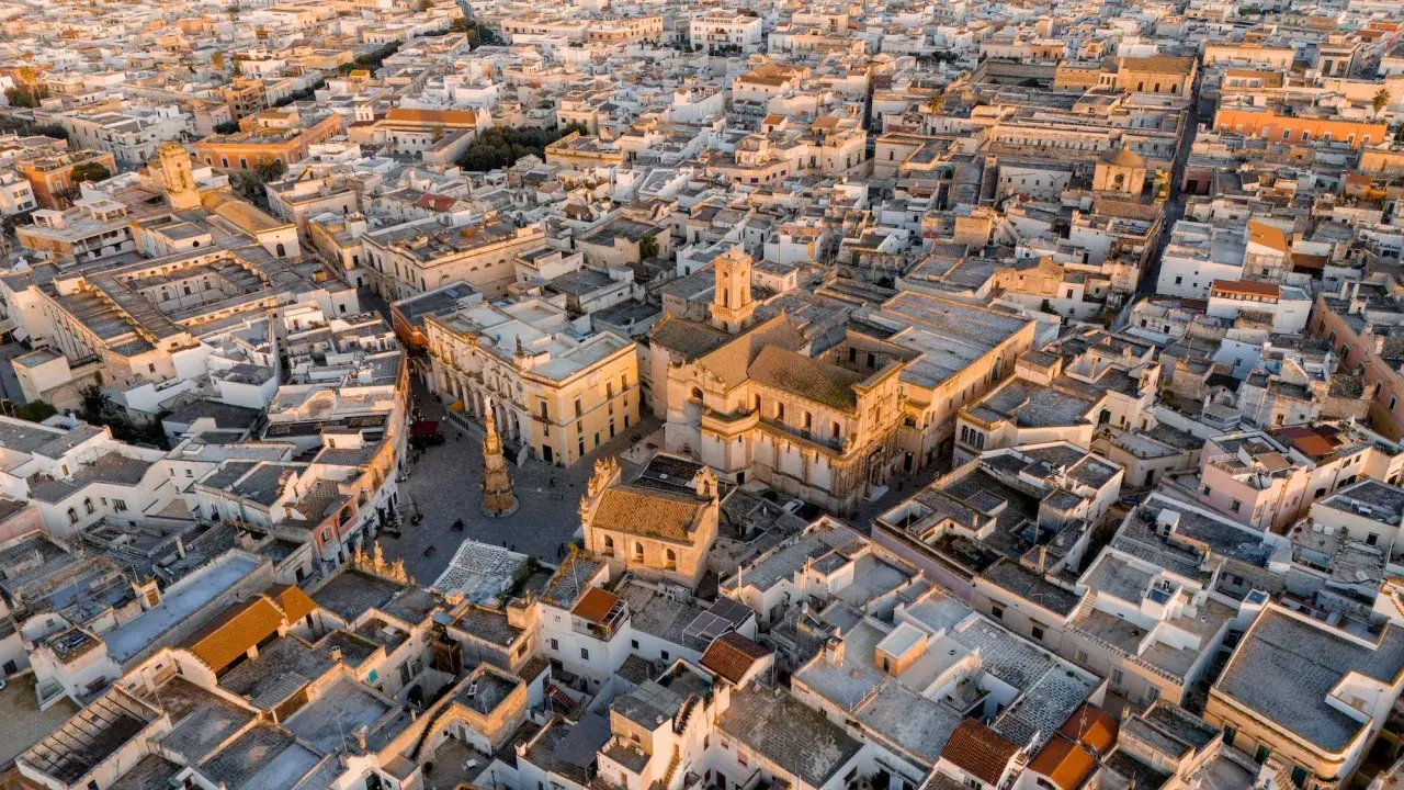 Nardò, dove si trova questo centro storico con chiese barocche e tetti bianchi, illuminato dalla luce dorata del tramonto.