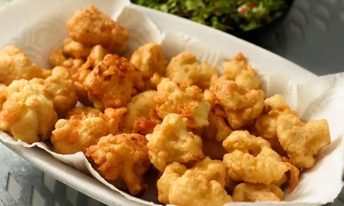 Un piatto colmo di croccante cavolfiore fritto, dorato e invitante, pronto per essere gustato.