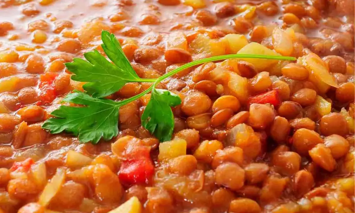 Lenticchie stufate con patate e pomodoro, un modo semplice per cucinare le lenticchie secche senza ammollo. Guarnite con prezzemolo fresco.