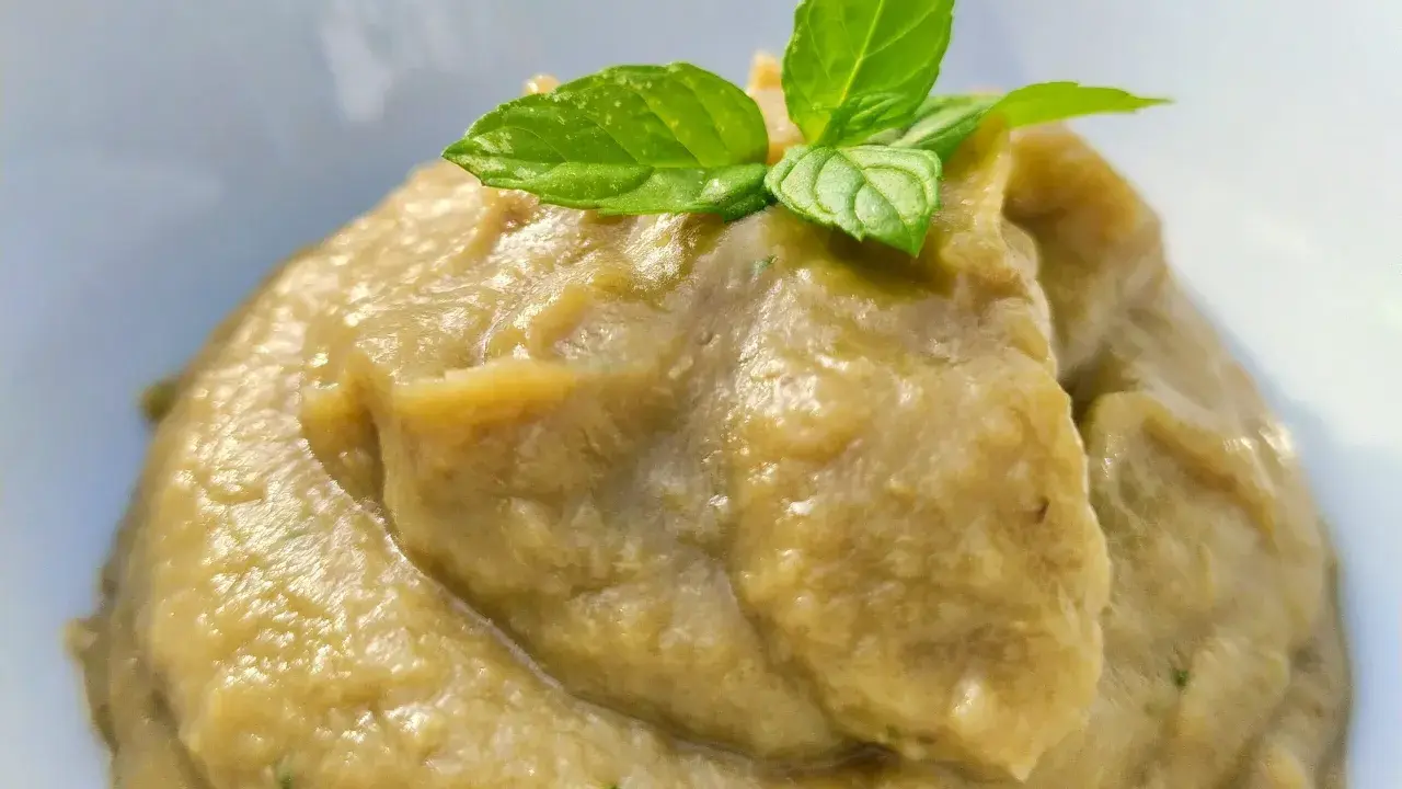 Crema di melanzane per pasta, liscia e vellutata, guarnita con foglie di menta fresca. Un sapore estivo pronto per condire il tuo piatto.