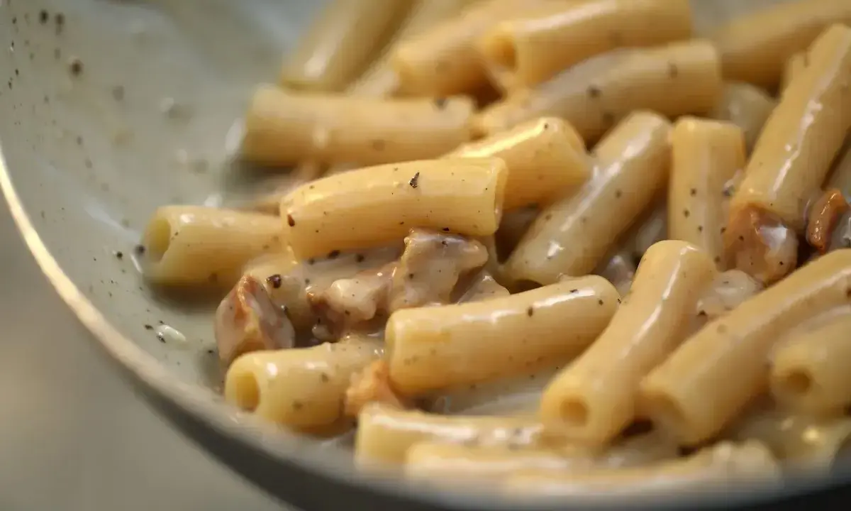 Primo piatto di pasta alla gricia, con rigatoni cremosi e guanciale croccante.
