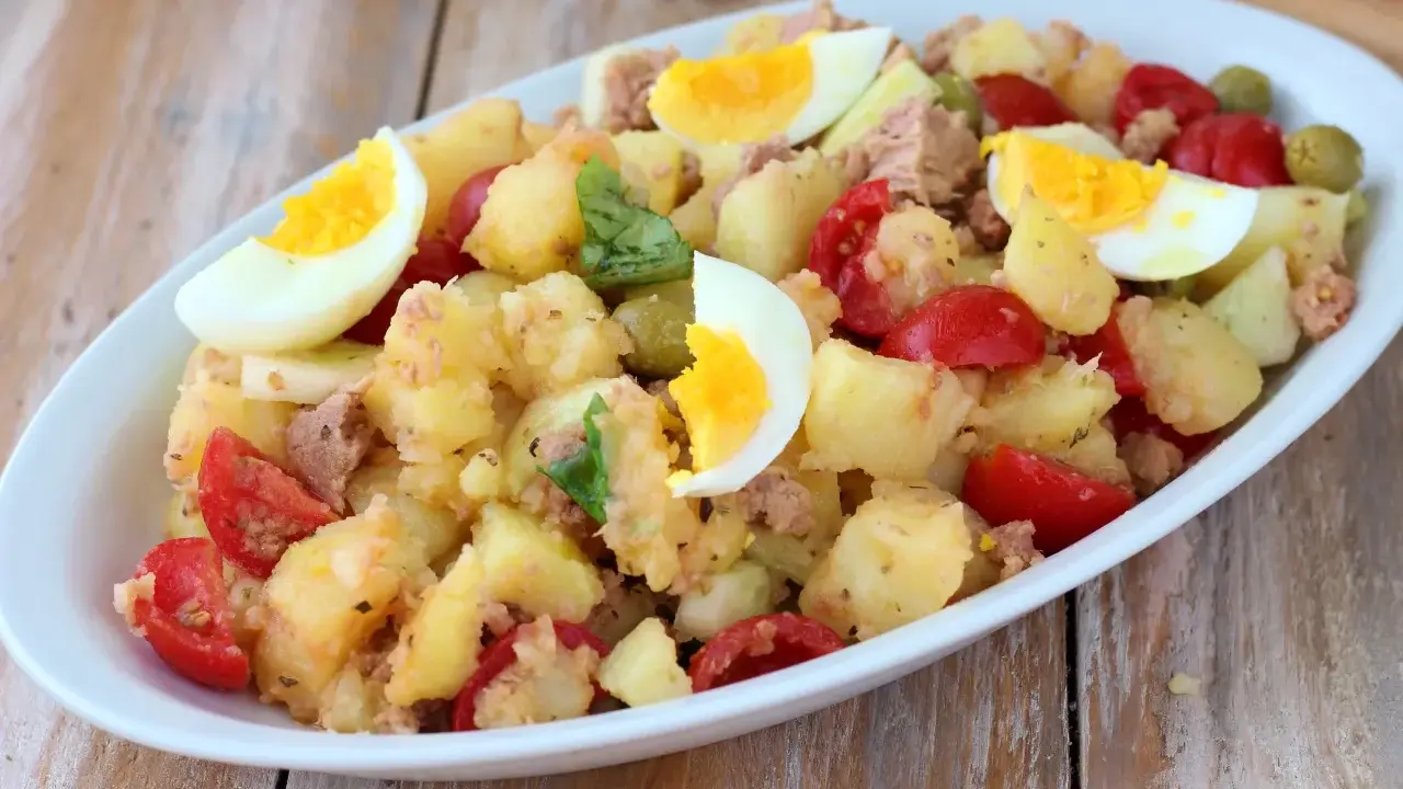 Deliziosa insalata di patate estiva con tonno, uova sode, pomodorini e olive. Un piatto fresco e saporito, perfetto per le giornate calde.