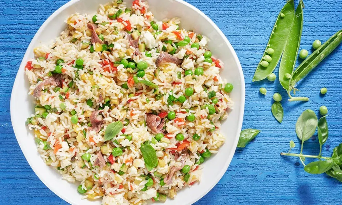 Un'idea fresca per le tue **riso freddo ricette**: un'insalata colorata con piselli, peperoni, acciughe e basilico.