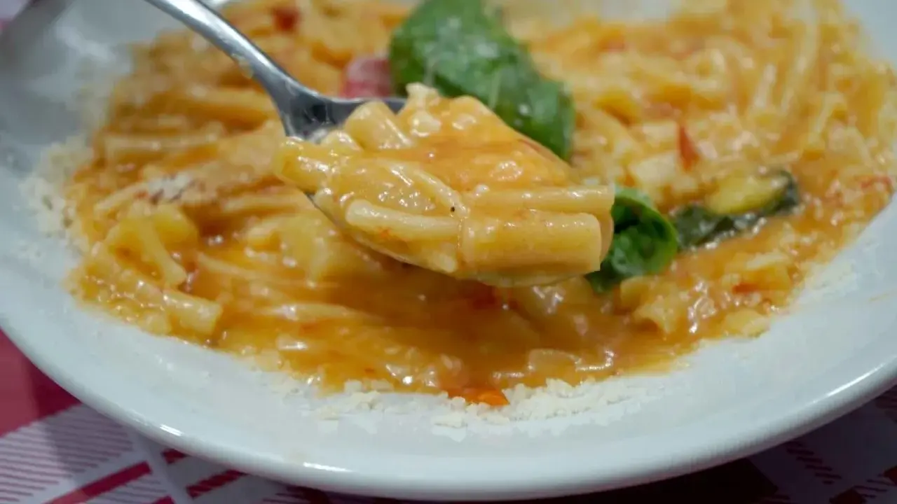 Un cucchiaio di pasta e patate alla napoletana, un piatto cremoso e saporito, con basilico fresco e parmigiano.