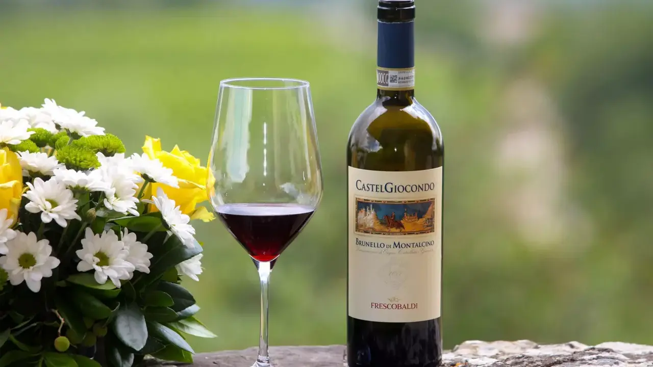 Un bicchiere di Brunello di Montalcino e un mazzo di fiori gialli e bianchi. Perfetti abbinamenti per una cena speciale.