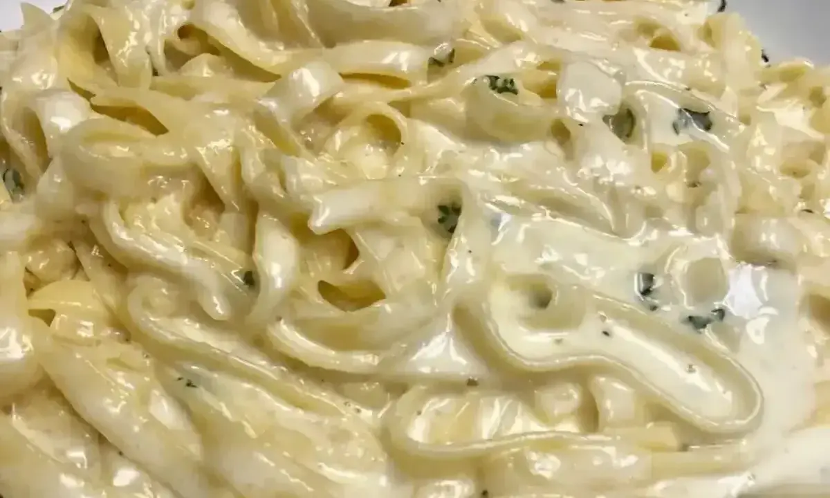 Un piatto cremoso di pasta burro e parmigiano, con erbe aromatiche tritate finemente.