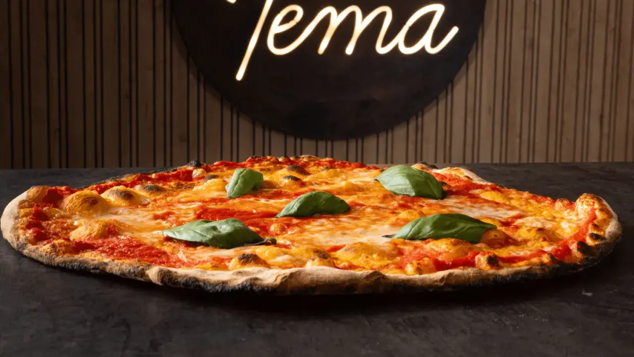 Pizza romana con pomodoro, mozzarella filante e basilico fresco. Ingredienti semplici per un gusto autentico.