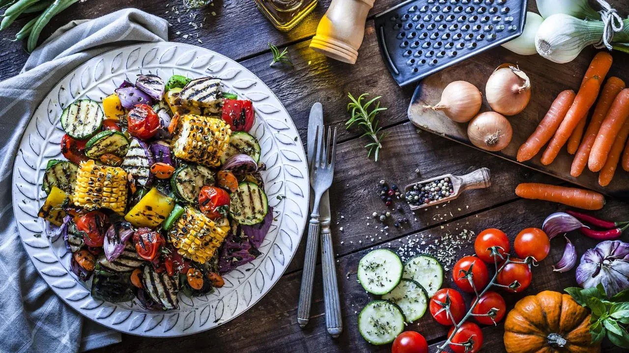 Piatto di contorni di verdure sfiziosi e veloci: zucchine, peperoni, cipolle, pomodorini e pannocchie grigliate, condite con erbe aromatiche.
