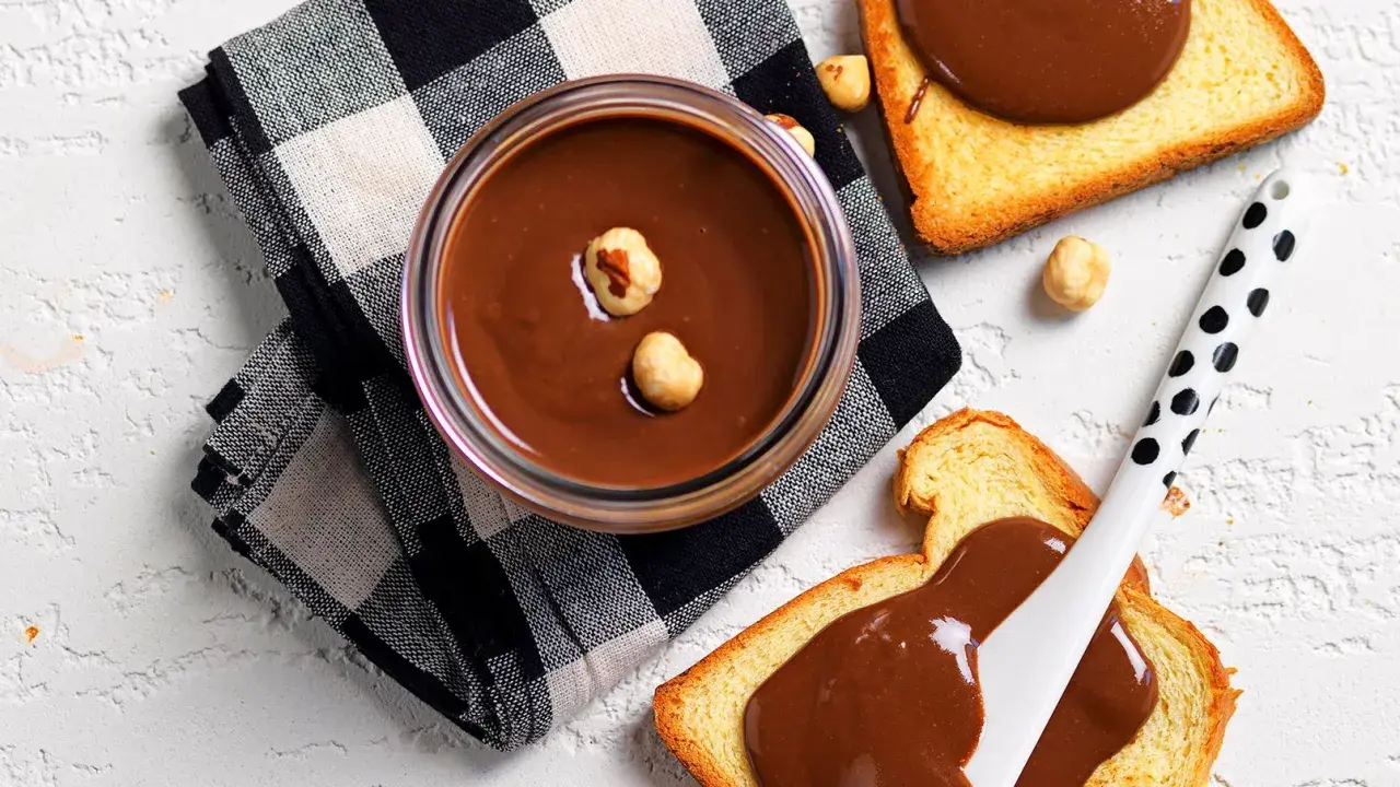 Crema di nocciole fatta in casa, vellutata e golosa, su fette biscottate. Un piacere semplice e genuino.
