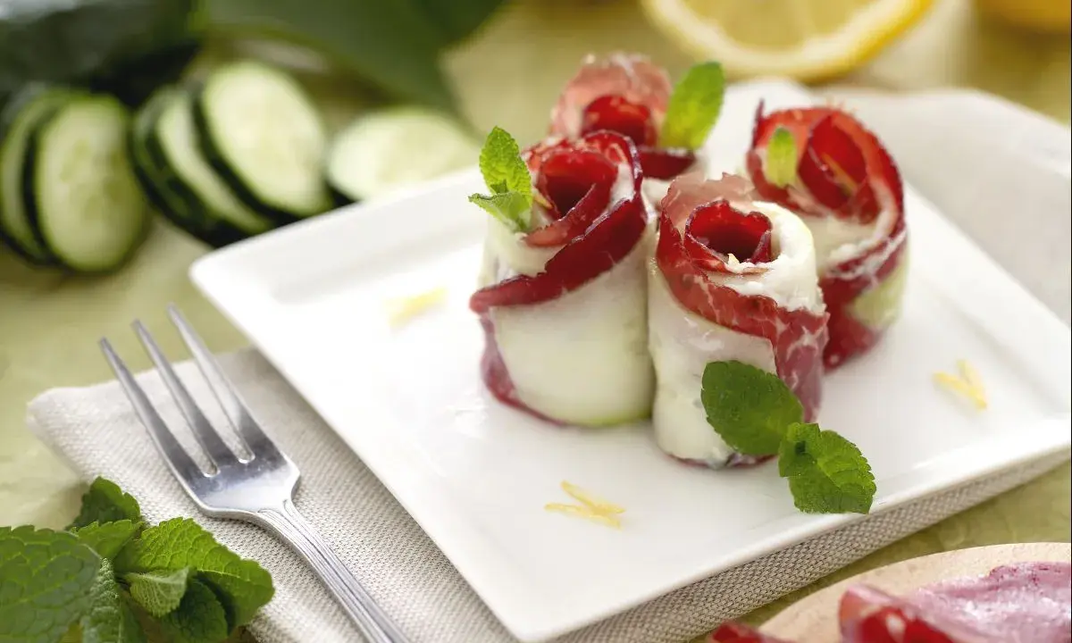 Rotolini di cetrioli con bresaola e formaggio, un'idea fresca per le tue cetrioli ricette. Guarniti con menta e scorza di limone.