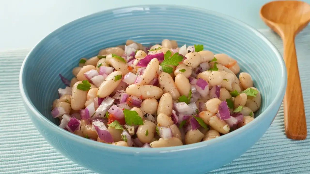 Insalata di fagioli in scatola con cipolla rossa e prezzemolo. Ecco come cucinarli per un contorno veloce e gustoso.