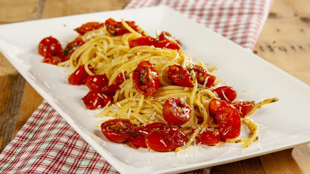 Spaghetti con pomodori al forno alla pugliese, un piatto semplice e gustoso, con pomodorini dolci e profumati.