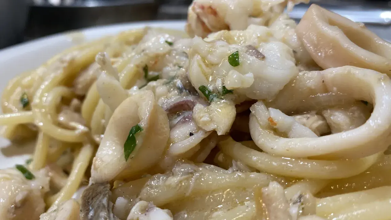Spaghetti con sugo di pesce, ricchi di calamari e gamberi, un piatto che profuma di mare.