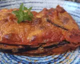 Parmigiana in padella, uno strato di melanzane fritte, pomodoro e formaggio, guarnita con basilico fresco.