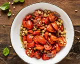 Insalata di ceci e pomodorini, un'idea fresca per le tue ricette con farina di ceci. Guarnita con pinoli e acciughe.