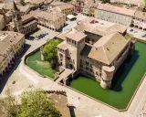 Castello con fossato e borgo storico. Un'idea di cosa vedere a Parma in un giorno, tra torri e tetti rossi.