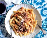 Un piatto invitante di pasta alla genovese, con maccheroni conditi con un ricco ragù di carne e spolverata di parmigiano.