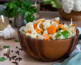 Un'appetitosa giardiniera in agrodolce, con cavolfiore, carote e cipolle, servita in una ciotola di legno.