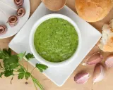 Salsa verde ricetta: prezzemolo fresco, aglio, acciughe arrotolate e pane per accompagnare.