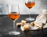 Calici di vino arancione, un'introduzione a cosa sono questi vini unici. Tappi e cavatappi completano la scena.
