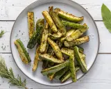 Zucchine in friggitrice ad aria, tagliate a bastoncini e condite con erbe aromatiche, pronte per essere gustate.
