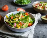 Insalata fresca con avocado, pomodorini, rucola e formaggio blu. Un piatto colorato e salutare.