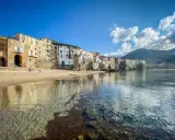 Cefalù, un gioiello da scoprire vicino a Palermo. Case colorate affacciate su una spiaggia dorata e un mare cristallino.