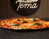 Pizza romana con pomodoro, mozzarella filante e basilico fresco. Ingredienti semplici per un gusto autentico.