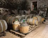 Cantina con botti di legno e damigiane, in attesa dell'affinamento del vino.