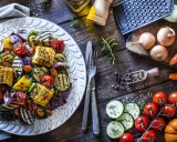 Piatto di contorni di verdure sfiziosi e veloci: zucchine, peperoni, cipolle, pomodorini e pannocchie grigliate, condite con erbe aromatiche.