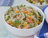Insalata di riso con gamberetti, mais e rucola, un piatto fresco e colorato, servito in una ciotola bianca.