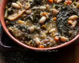 Un piatto fumante di ribollita toscana, con fagioli cannellini, cavolo nero e pane raffermo in un'autentica ciotola di terracotta.
