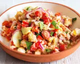 Panzanella ricetta: un'insalata estiva con pane raffermo, pomodori, cetrioli, cipolla rossa e basilico, condita con olio d'oliva.