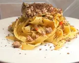 Tagliatelle al ragù con scaglie di tartufo nero, un piatto ricco e profumato, pronto per essere gustato.