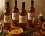 Quattro bottiglie di Pinot Grigio Ramato, una ciotola di zuppa di zucca e spicchi di zucca arrosto, perfetti per i tuoi pinot grigio abbinamenti autunnali.