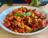 Caponata siciliana ricetta della nonna: un piatto colorato con melanzane, peperoni, pomodorini e basilico, pronto per essere gustato.