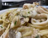 Spaghetti con sugo di pesce, ricchi di calamari e gamberi, un piatto che profuma di mare.