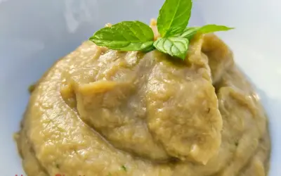 Crema di melanzane per pasta, liscia e vellutata, guarnita con foglie di menta fresca. Un sapore estivo pronto per condire il tuo piatto.