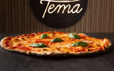 Pizza romana con pomodoro, mozzarella filante e basilico fresco. Ingredienti semplici per un gusto autentico.