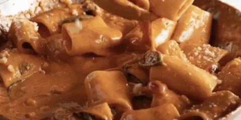 Un primo piatto cremoso e invitante: paccheri alla Vittorio, ricoperti da una salsa ricca e profumata, con un tocco di parmigiano.