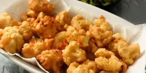 Un piatto colmo di croccante cavolfiore fritto, dorato e invitante, pronto per essere gustato.