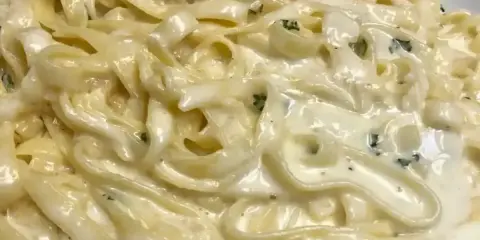 Un piatto cremoso di pasta burro e parmigiano, con erbe aromatiche tritate finemente.