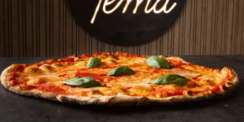 Pizza romana con pomodoro, mozzarella filante e basilico fresco. Ingredienti semplici per un gusto autentico.