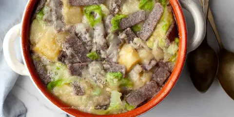 Pizzoccheri ricetta: un piatto fumante di pasta di grano saraceno, patate, verza e formaggio fuso in una casseruola.