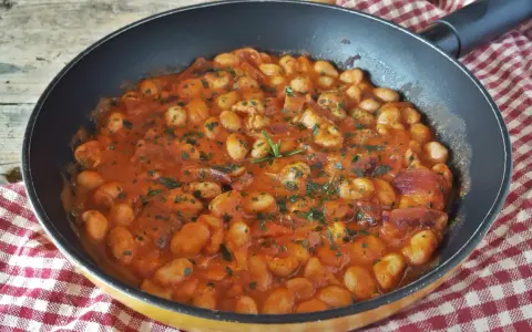 Fagioli alla Bud Spencer in padella, un piatto saporito e confortante, con pomodoro, pancetta e rosmarino.