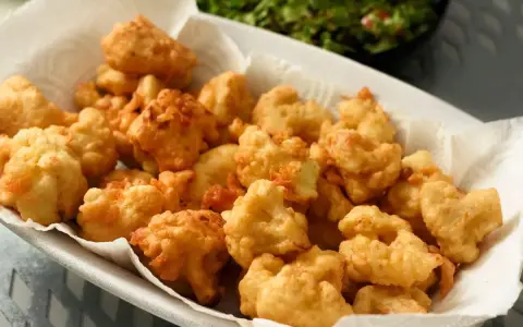 Un piatto colmo di croccante cavolfiore fritto, dorato e invitante, pronto per essere gustato.