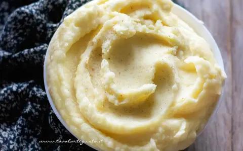 Una ciotola di cremosa crema di patate, soffice e invitante, con un pizzico di pepe nero.