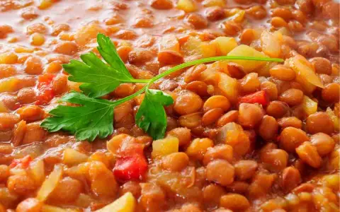 Lenticchie stufate con patate e pomodoro, un modo semplice per cucinare le lenticchie secche senza ammollo. Guarnite con prezzemolo fresco.