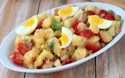Deliziosa insalata di patate estiva con tonno, uova sode, pomodorini e olive. Un piatto fresco e saporito, perfetto per le giornate calde.