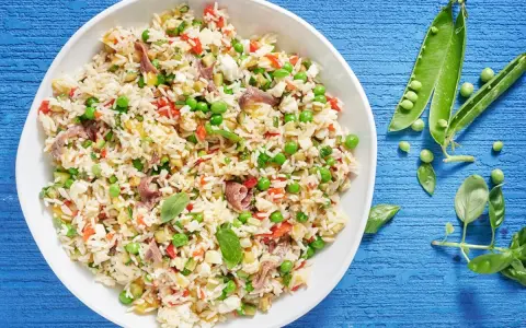 Un'idea fresca per le tue **riso freddo ricette**: un'insalata colorata con piselli, peperoni, acciughe e basilico.